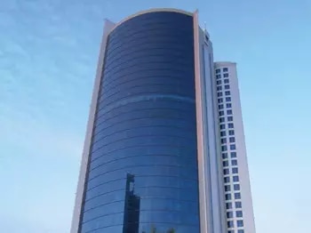 The iconic Bahrain Financial Harbour, a striking example of modern architecture with its twin towers soaring into a blue, cloud-dotted sky—home to prestigious Servcorp serviced offices,